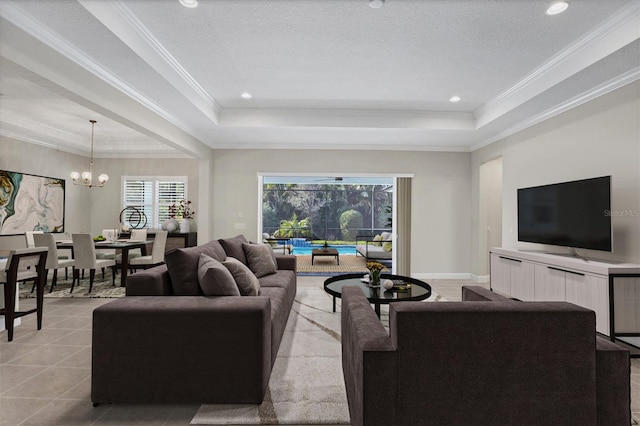 living room with a tray ceiling, crown molding, a textured ceiling, and an inviting chandelier