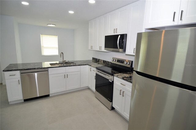 kitchen with white cabinetry, sink, appliances with stainless steel finishes, and dark stone counters