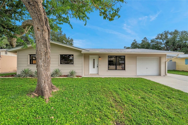 ranch-style home with a garage and a front lawn