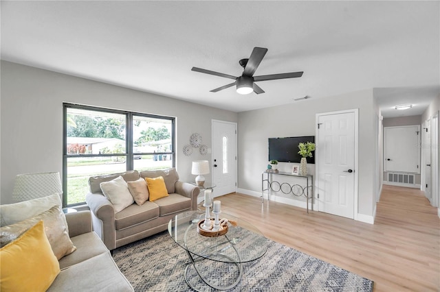 living room with light hardwood / wood-style flooring and ceiling fan