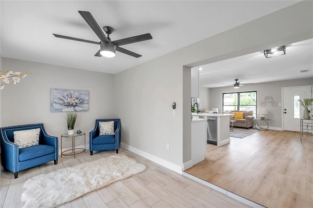 sitting room featuring ceiling fan and light hardwood / wood-style floors