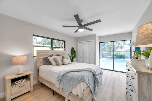 bedroom with multiple windows, a closet, access to outside, and light hardwood / wood-style flooring