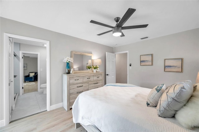 bedroom with ceiling fan, ensuite bathroom, and light hardwood / wood-style floors