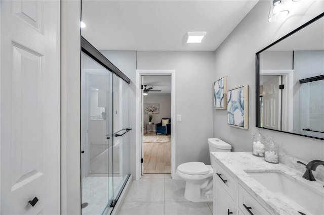 bathroom featuring ceiling fan, toilet, walk in shower, and vanity