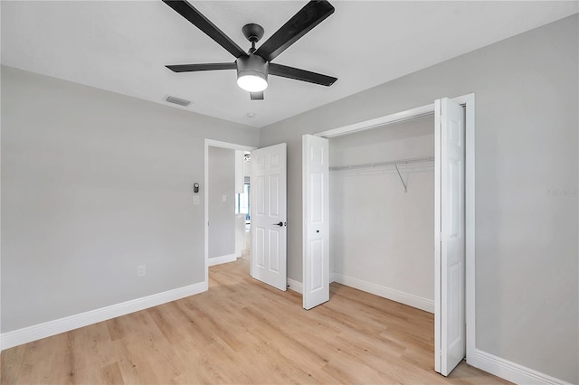 unfurnished bedroom with light wood-type flooring, ceiling fan, and a closet