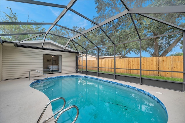 view of swimming pool featuring a patio area and glass enclosure