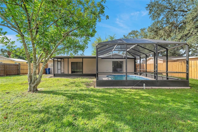 back of house with a yard, a fenced in pool, and glass enclosure