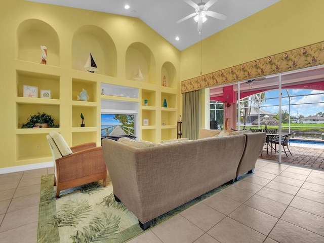 living room with built in shelves, high vaulted ceiling, ceiling fan, and tile patterned floors