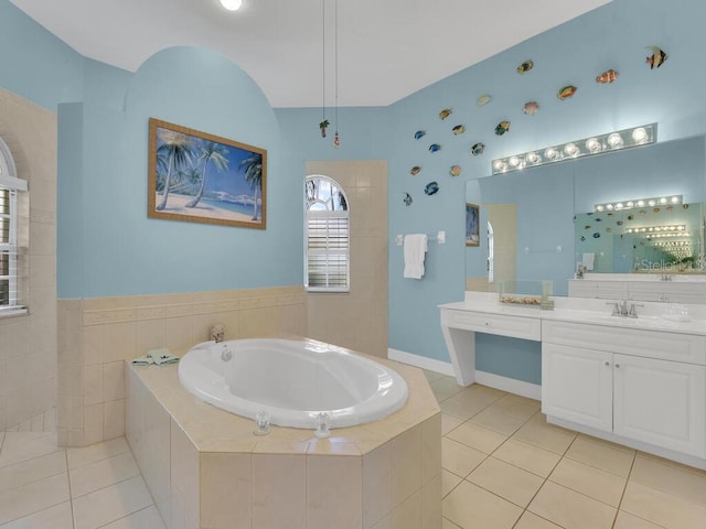 full bath with tile patterned flooring, a bath, vanity, and baseboards