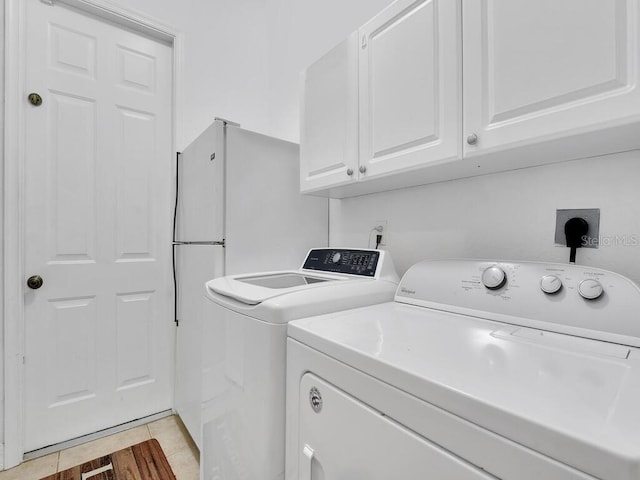 washroom featuring cabinet space, light wood finished floors, and washer and clothes dryer