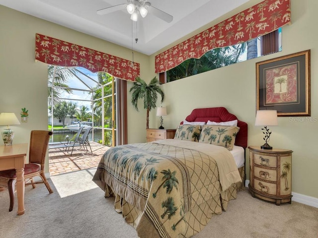 carpeted bedroom featuring access to exterior, a ceiling fan, and baseboards