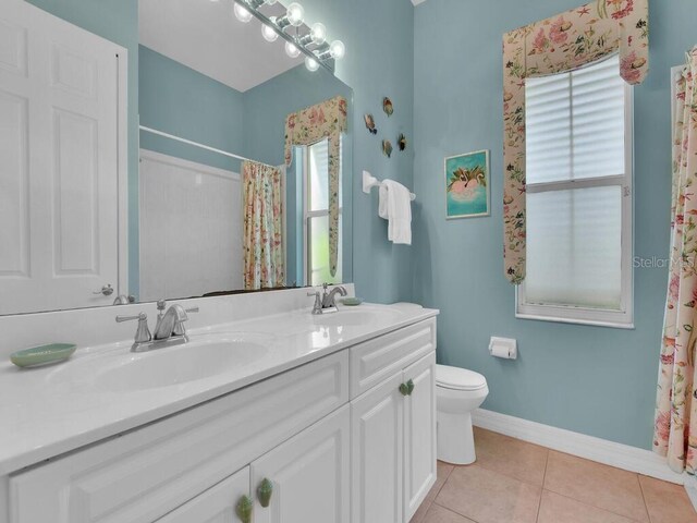 full bathroom with a sink, baseboards, toilet, and tile patterned floors