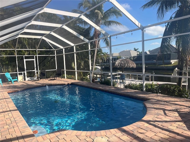 outdoor pool featuring glass enclosure and a patio area