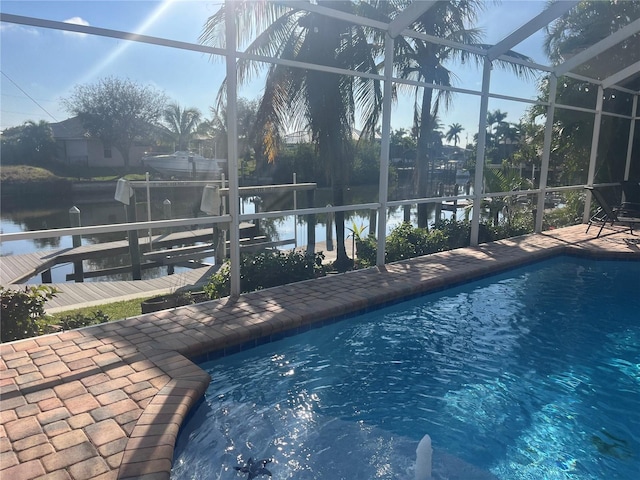 pool with a water view, a dock, glass enclosure, boat lift, and a patio area