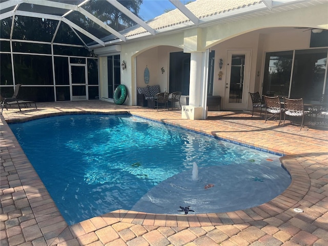 outdoor pool with a lanai, a patio area, and ceiling fan