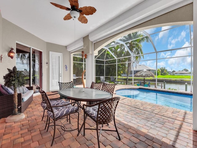 pool featuring a patio area, glass enclosure, ceiling fan, and a water view