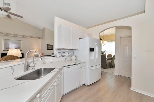 kitchen with white cabinets, lofted ceiling, sink, white appliances, and ceiling fan with notable chandelier