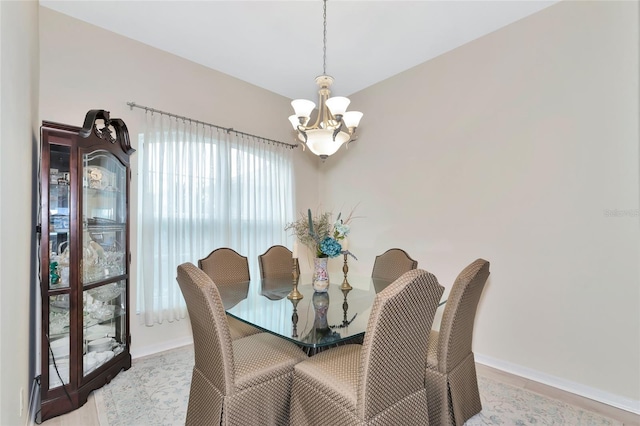 dining space featuring light hardwood / wood-style floors and an inviting chandelier