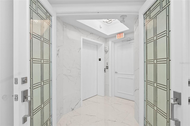 hall with marble finish floor and elevator