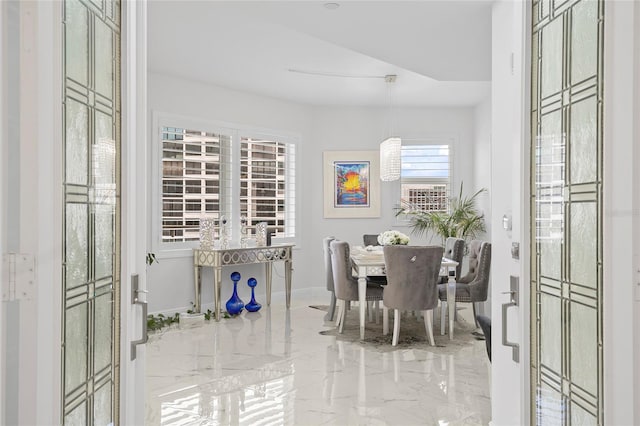 dining room featuring marble finish floor and baseboards