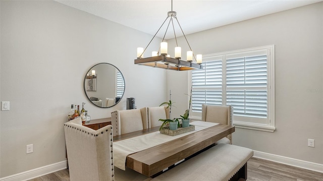 dining area featuring wood-type flooring and a chandelier