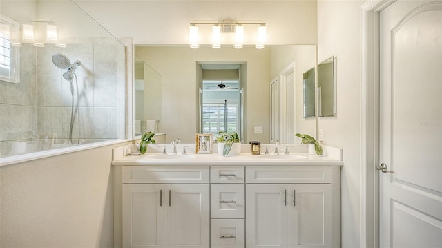 bathroom featuring a wealth of natural light, vanity, and tiled shower