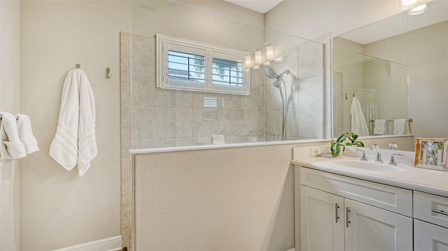 bathroom with a tile shower and vanity