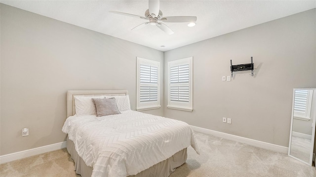 bedroom with ceiling fan and light carpet