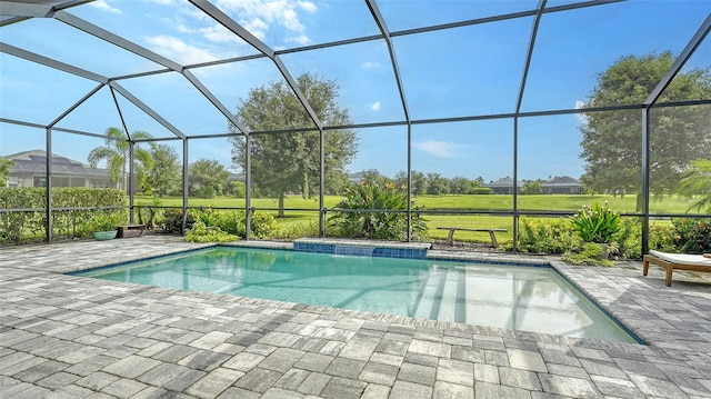 view of pool with glass enclosure and a patio area