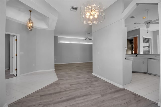 unfurnished living room featuring ceiling fan with notable chandelier, light wood-type flooring, and sink