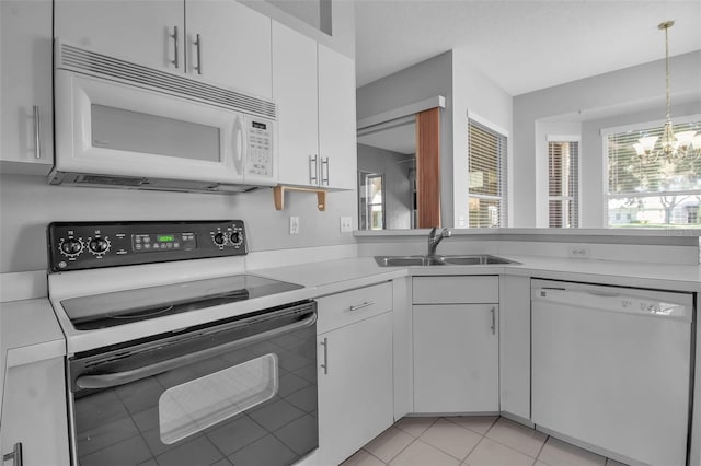 kitchen with white appliances, white cabinetry, and a chandelier