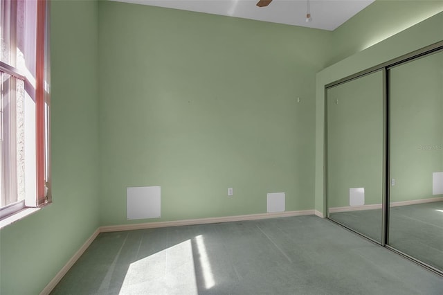 unfurnished bedroom featuring ceiling fan, a closet, and carpet