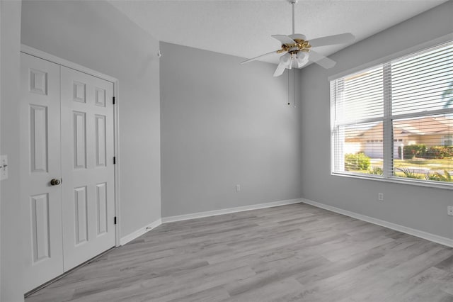 empty room featuring a textured ceiling, light hardwood / wood-style floors, and ceiling fan