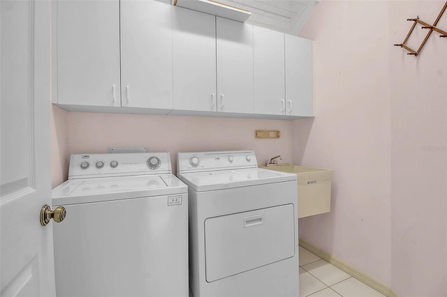 clothes washing area with washer and clothes dryer, cabinets, sink, and light tile patterned flooring