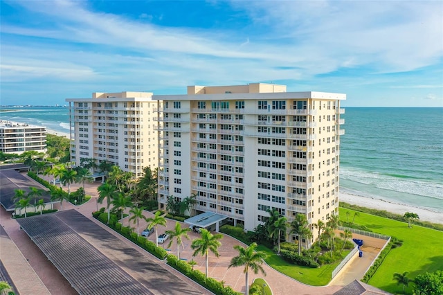 view of property with a water view and a beach view