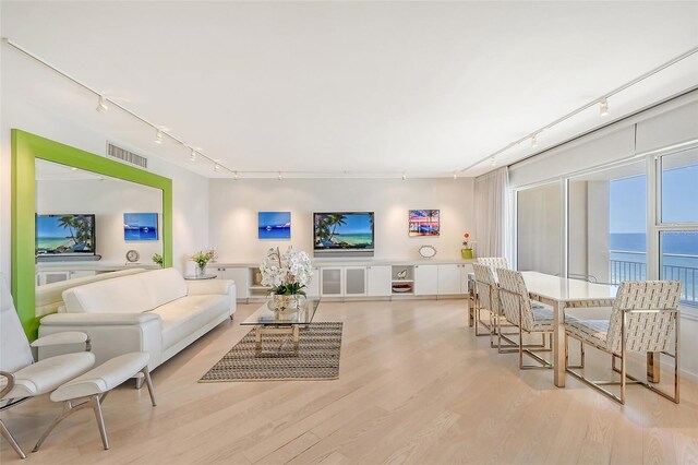 living room with visible vents, track lighting, and wood finished floors