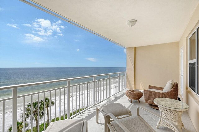 balcony featuring a water view, a sunroom, and a beach view