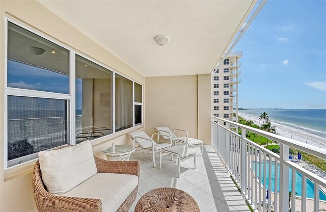 balcony featuring a beach view and a water view