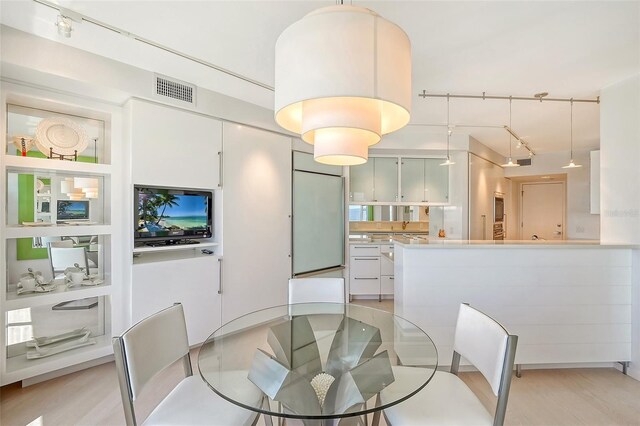 dining space featuring track lighting, visible vents, and light wood finished floors