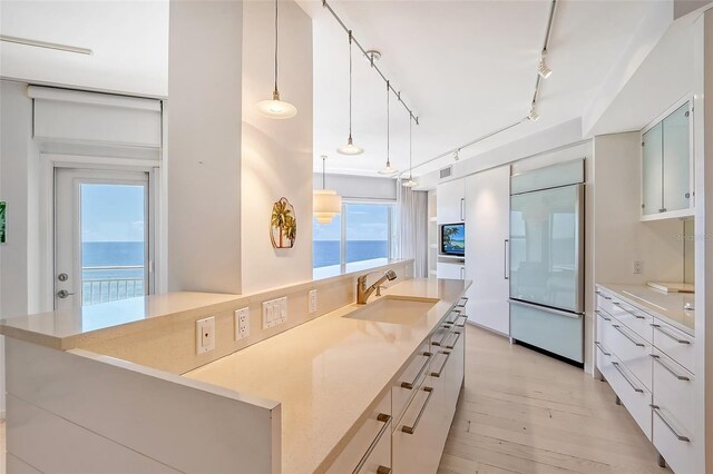 kitchen with built in refrigerator, modern cabinets, and a sink