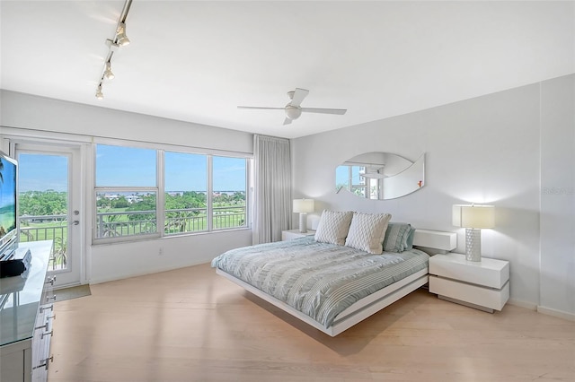 bedroom with a ceiling fan, baseboards, access to exterior, rail lighting, and light wood-style floors