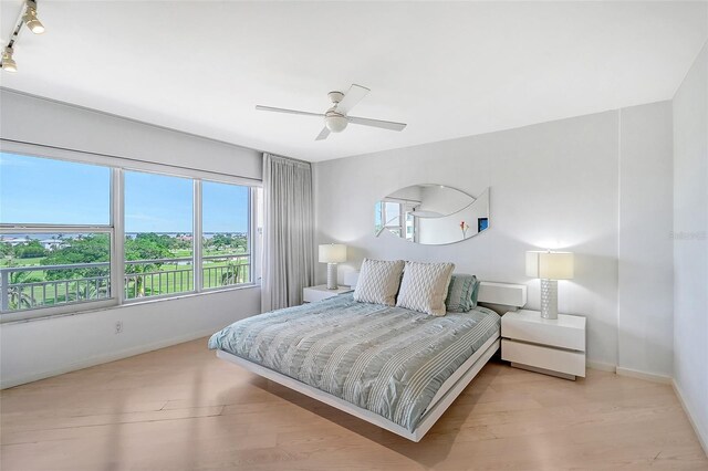 bedroom featuring baseboards, wood finished floors, and a ceiling fan