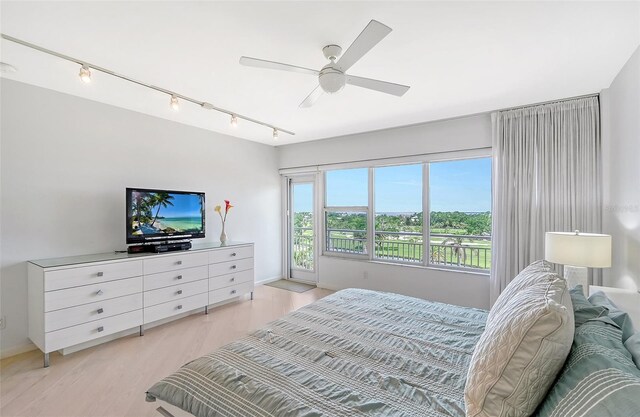 bedroom featuring track lighting, light wood-style flooring, and a ceiling fan