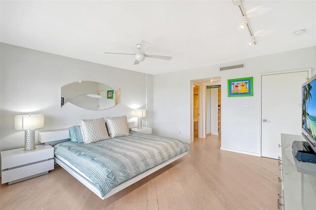 bedroom with visible vents, track lighting, light wood-style flooring, and a ceiling fan