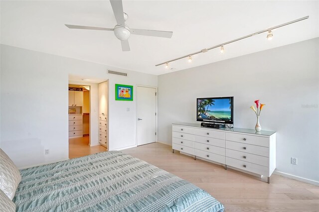 bedroom with light wood finished floors, visible vents, and ceiling fan