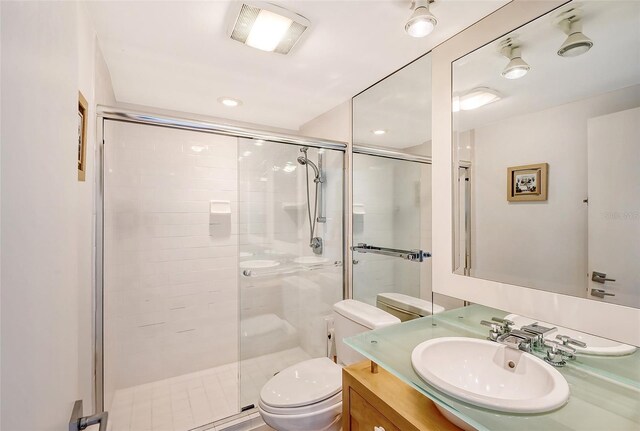 bathroom with visible vents, vanity, toilet, and a shower stall