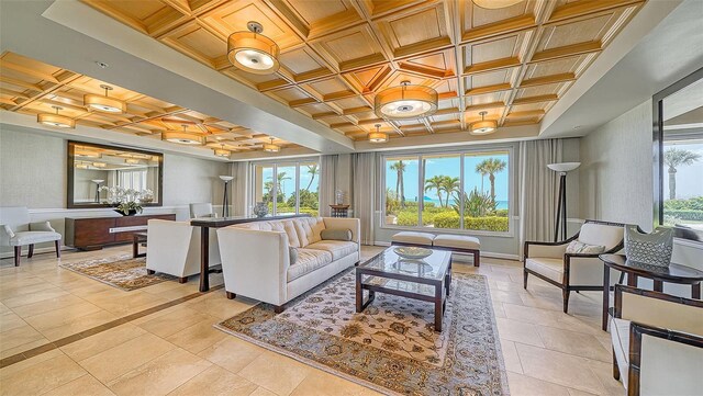 living area featuring plenty of natural light, baseboards, and coffered ceiling