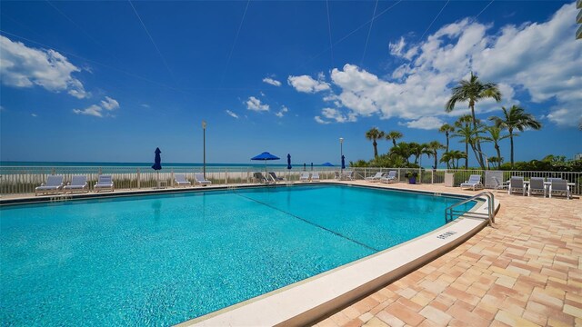 community pool with a patio and fence