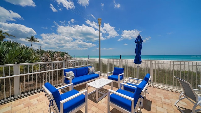 view of patio / terrace with an outdoor hangout area, a beach view, and a water view