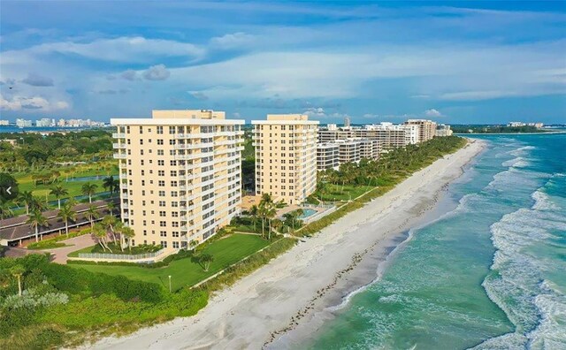 drone / aerial view with a water view, a city view, and a beach view